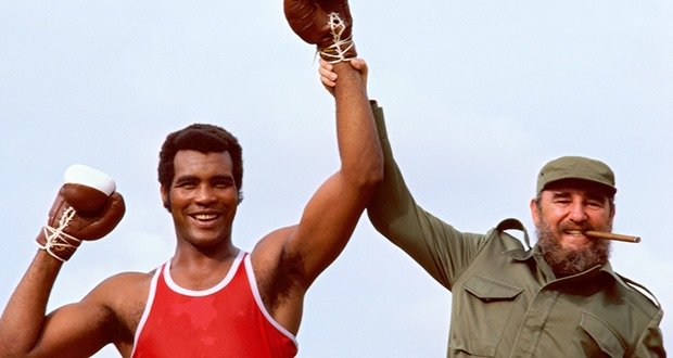 Portrait of Cuban President Fidel Castro holding the arm of heavyweight Olympic boxer Teofilo Stevenson during photo shoot. Havana, Cuba 4/1984 (Image # 1139 )