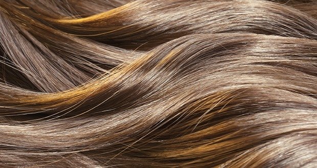 Beautiful healthy shiny hair texture with highlighted golden streaks