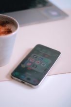 a cup of coffee next to a cell phone
